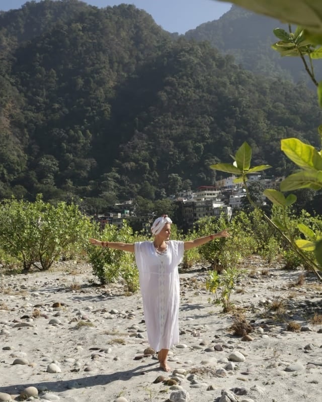 A woman in a white dress with open arms