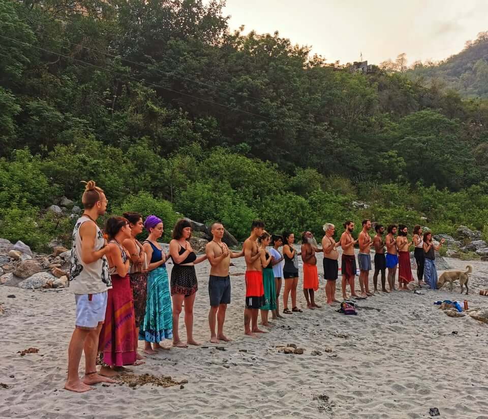 Group of people performing a yoga ceremony on the beach