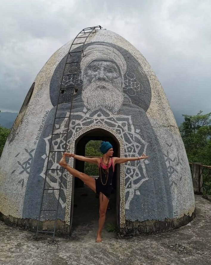 A woman in nature in a standing yoga pose